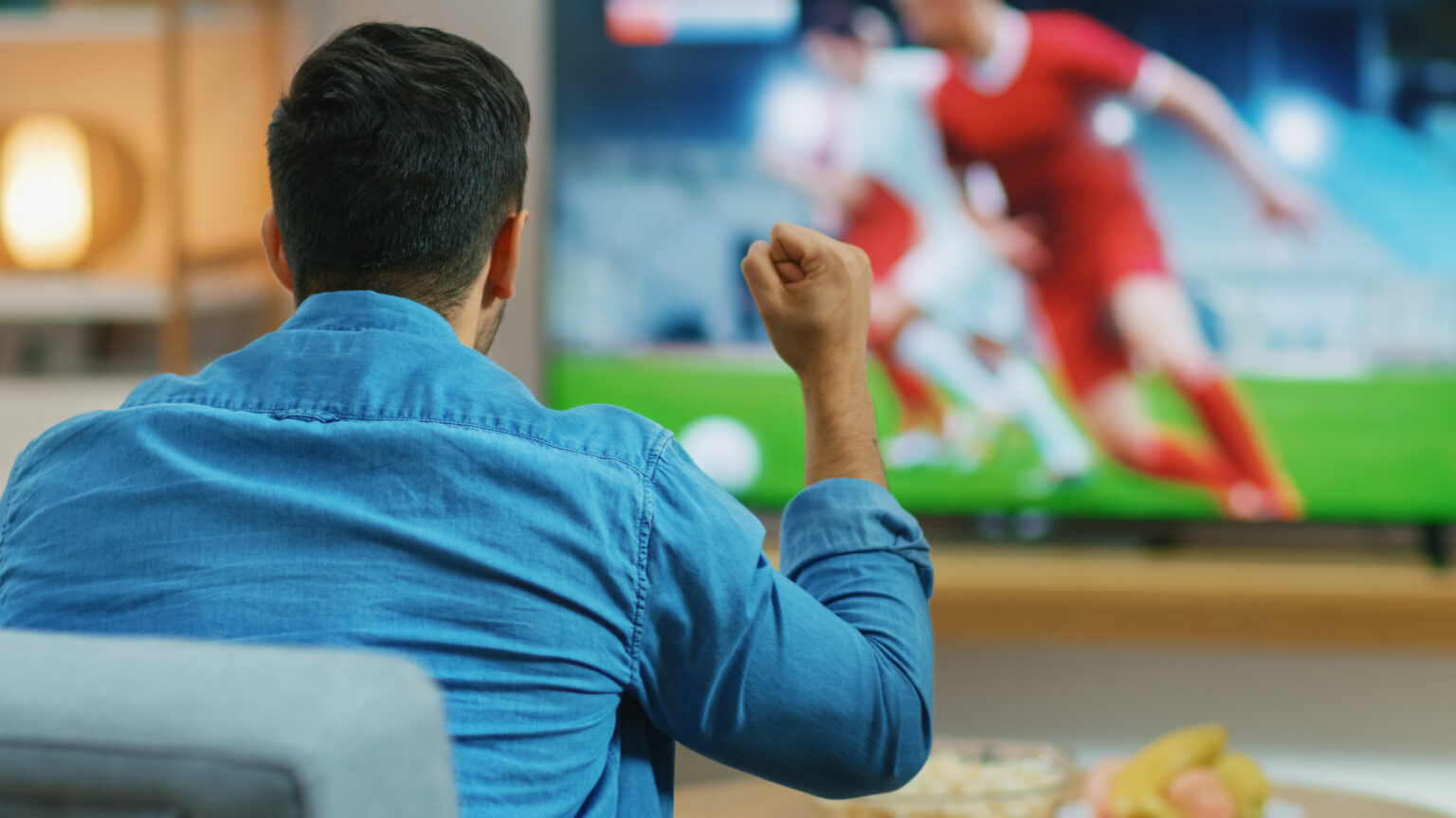 Man watching sports on a large TV at home