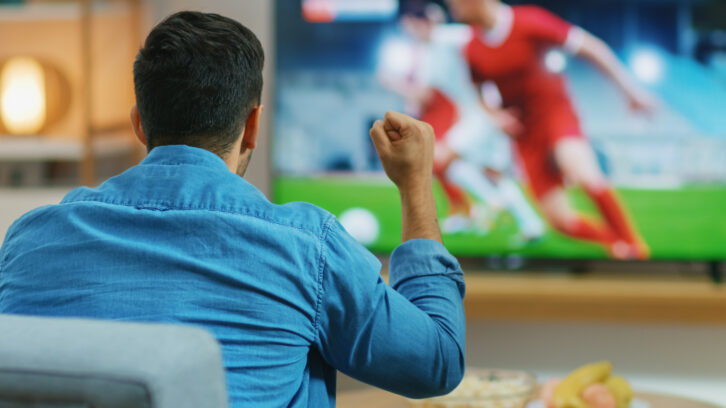 Man watching sports on a large TV at home