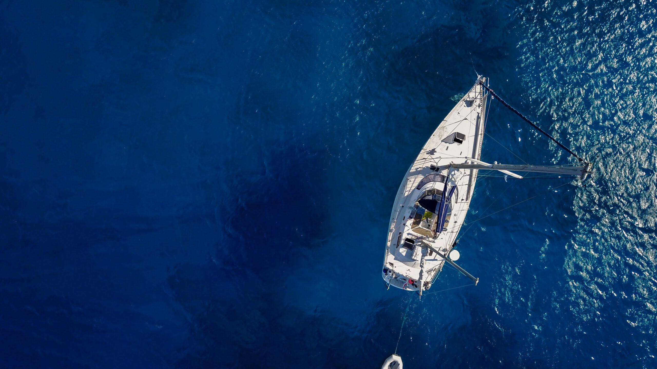 Aerial view of the white luxury yacht in the exotic turquoise sea.